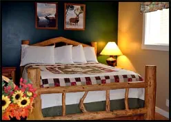 Comfortable queen bed with country ambiance in the Deer-Elk Room.