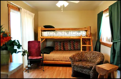 Homey sitting room with log-style bunk bed and zebra-striped chair in the Sunflower Suite